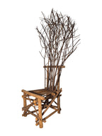 Vintage, handmade rustic twig chair in a left-front view featuring tall, branching backrest, slatted branch seat, and cross-braced legs. Made from raw branches with unpeeled bark. Sold vintage as-is in very good condition.