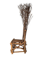 Vintage, handmade rustic twig chair in left-profile view featuring tall, branching backrest, slatted branch seat, and cross-braced legs. Made from raw branches with unpeeled bark. Sold vintage as-is in very good condition.
