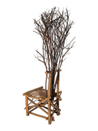 Vintage, handmade rustic twig chair in a left-back view featuring tall, branching backrest, slatted branch seat, and cross-braced legs. Made from raw branches with unpeeled bark. Sold vintage as-is in very good condition.