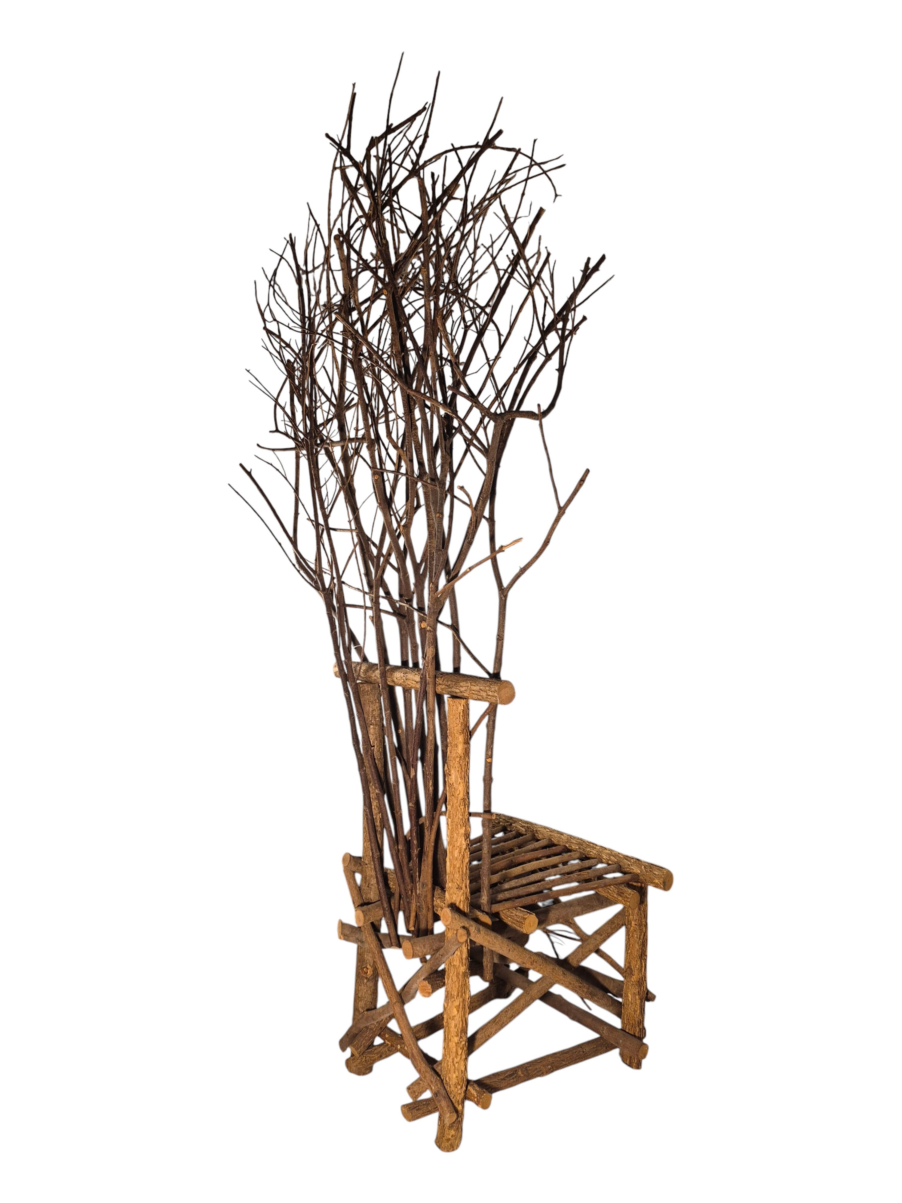 Vintage, handmade rustic twig chair in a right-back view featuring tall, branching backrest, slatted branch seat, and cross-braced legs. Made from raw branches with unpeeled bark. Sold vintage as-is in very good condition.