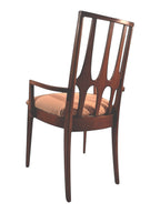 Mid Century Modern Broyhill Brasilia walnut arm dining chair in a back-left view. Features a signature cathedral slatted back and original beige geometric upholstered seat. Vintage as-is, gently refreshed, as part of a set of six.