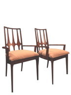 Mid Century Modern Broyhill Brasilia walnut arm dining chair displayed two side by side. Features a signature cathedral slatted back and original beige geometric upholstered seat. Vintage as-is, gently refreshed, as part of a set of six.