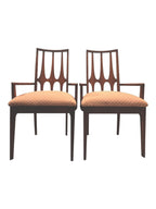 Mid Century Modern Broyhill Brasilia walnut arm dining chair displayed two side by side. Features a signature cathedral slatted back and original beige geometric upholstered seat. Vintage as-is, gently refreshed, as part of a set of six.