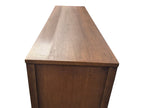 Mid Century Modern Broyhill Brasilia walnut base credenza, the lower half of the breakfront China cabinet set, in a left profile view. Features the Brasilia collection's catseye sweeping arches, tapered legs, and brass hardware. Vintage as-is, gently refreshed, as a pair with top display deck.