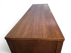 Mid Century Modern Broyhill Brasilia walnut base credenza, the lower half of the breakfront China cabinet set, in a right profile view. Features the Brasilia collection's catseye sweeping arches, tapered legs, and brass hardware. Vintage as-is, gently refreshed, as a pair with top display deck.