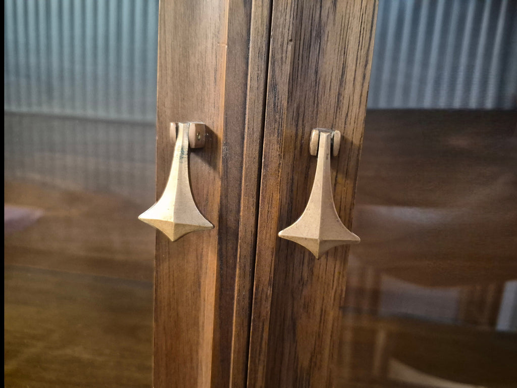 Mid Century Modern Broyhill Brasilia walnut breakfront China cabinet detail shot displaying brass pendant pull hardware on the breakfront doors.