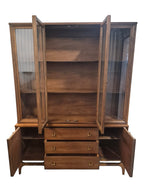 Mid Century Modern Broyhill Brasilia walnut breakfront China cabinet in a front view, with open doors and drawers. Features the Brasilia collection's catseye sweeping arches and tapered legs, with brass hardware and glass display doors. Vintage as-is, gently refreshed, including credenza base with three drawers and two doors and top display deck with two doors.