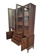 Mid Century Modern Broyhill Brasilia walnut breakfront China cabinet in a left-front view, with open doors and drawers. Features the Brasilia collection's catseye sweeping arches and tapered legs, with brass hardware and glass display doors. Vintage as-is, gently refreshed, including credenza base with three drawers and two doors and top display deck with two doors.