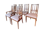 Mid Century Modern Broyhill Brasilia walnut side dining chairs in a, a set of six arranged side by side, two arm chairs in front, four side chairs behind. Features a signature cathedral slatted back and original beige geometric upholstered seat. Vintage as-is, gently refreshed, as part of a set of six.