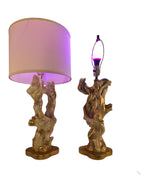 Vintage 1950s mid-century modern sculptural table lamp made of chalkware plaster, shaped like twisted biomorphic driftwood featuring a white gesso finish with hand-painted gold leaf highlights, sitting on a scalloped gold base against a white backdrop.