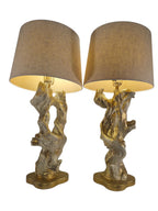 Vintage 1950s mid-century modern sculptural table lamp made of chalkware plaster, shaped like twisted biomorphic driftwood featuring a white gesso finish with hand-painted gold leaf highlights, sitting on a scalloped gold base against a white backdrop.