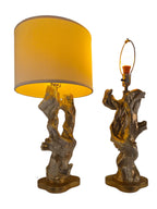 Vintage 1950s mid-century modern sculptural table lamp made of chalkware plaster, shaped like twisted biomorphic driftwood featuring a white gesso finish with hand-painted gold leaf highlights, sitting on a scalloped gold base against a white backdrop.