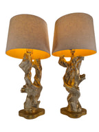 Vintage 1950s mid-century modern sculptural table lamp made of chalkware plaster, shaped like twisted biomorphic driftwood featuring a white gesso finish with hand-painted gold leaf highlights, sitting on a scalloped gold base against a white backdrop.