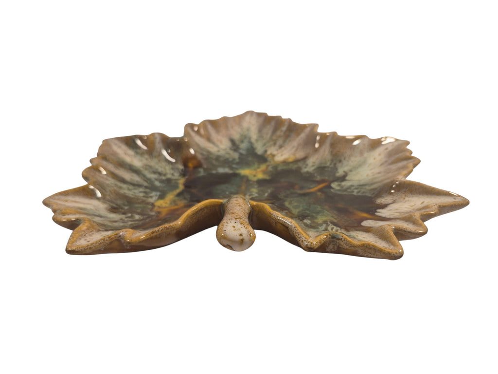 Curated Vintage Design leaf-shaped ceramic dish with multi-tonal green, brown, and yellow glaze. Features raised edges and a glossy finish.