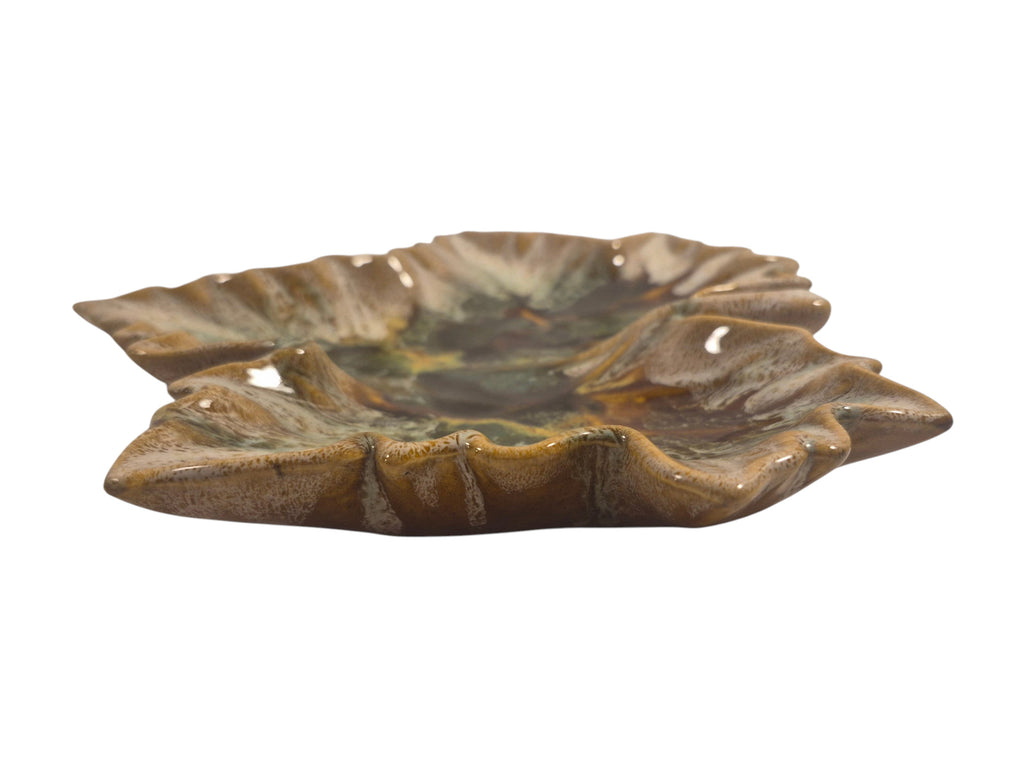 Curated Vintage Design leaf-shaped ceramic dish with multi-tonal green, brown, and yellow glaze. Glossy finish.