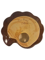 Close-up view of the unglazed tan clay bottom of a vintage Van Briggle pottery tray, showing hand-incised markings that read 'Van Briggle' and 'Colo. Spgs.' alongside the iconic Double A logo and a square emblem. A clean, round pre-drilled hole is visible in the center, surrounded by a glossy brown glazed rim. Vintage as-is.