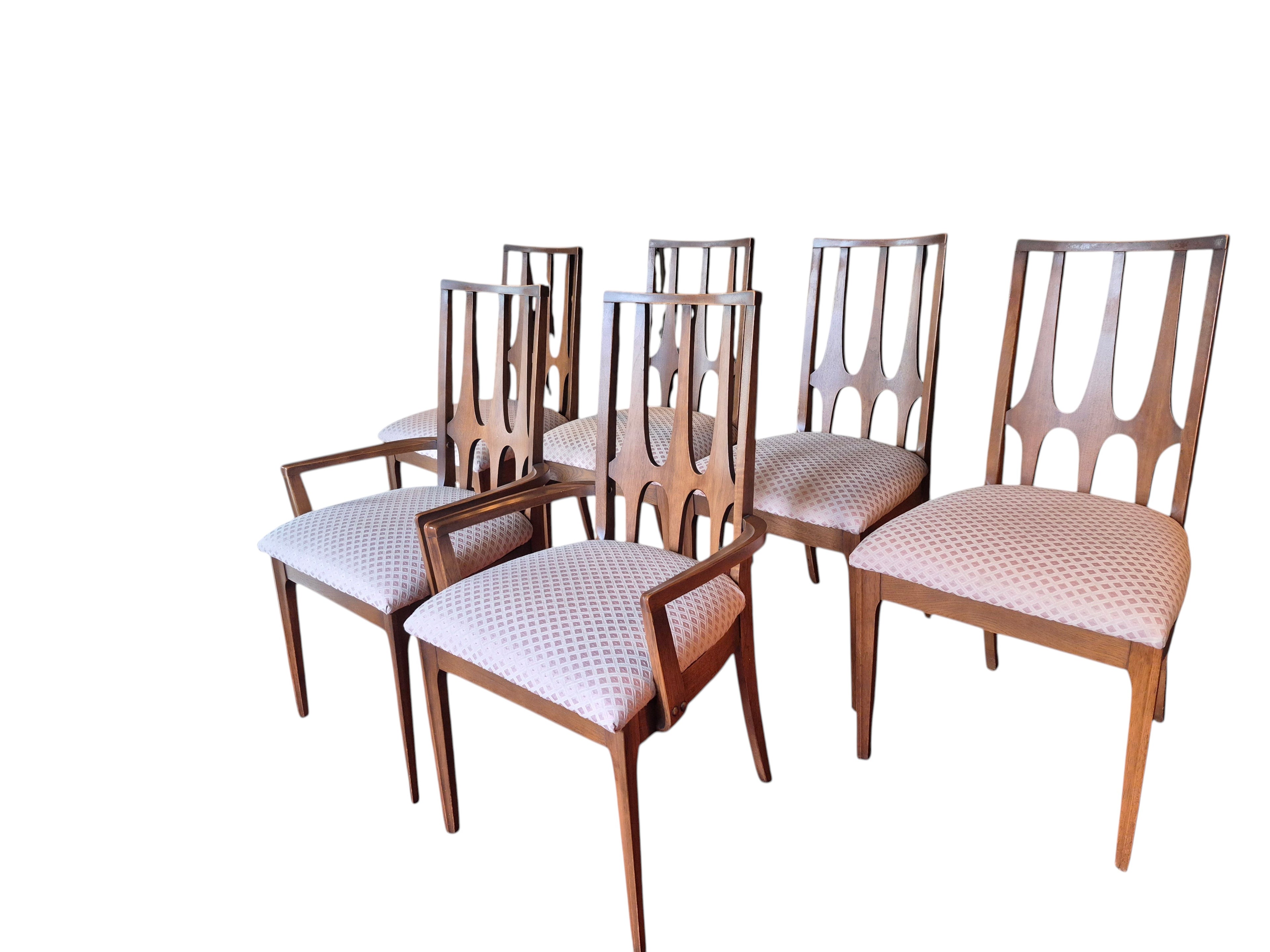 Curated Vintage Design set of 6 walnut dining chairs with carved parabolic arches and light patterned upholstery. Includes 2 captain's chairs and 4 side chairs.